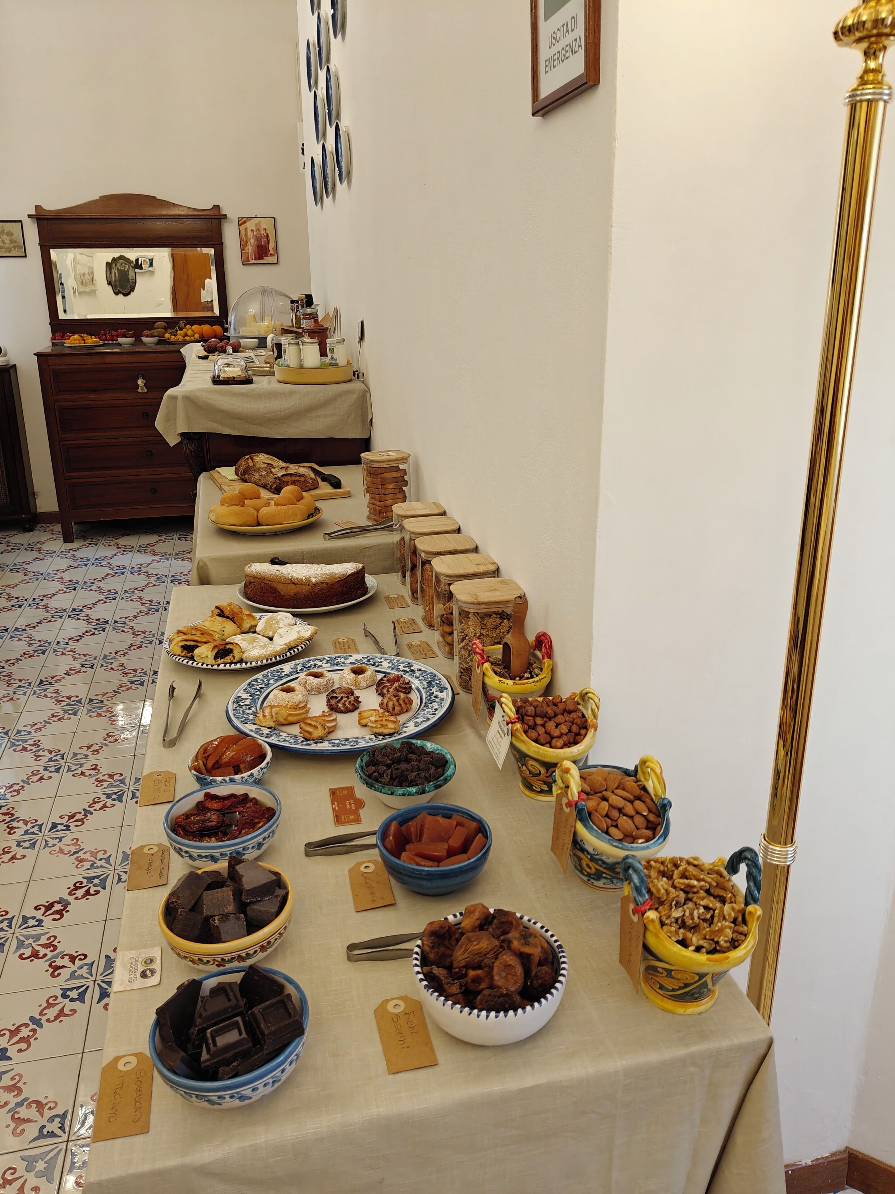A buffet table with various food items and a wooden cabinet in the background.