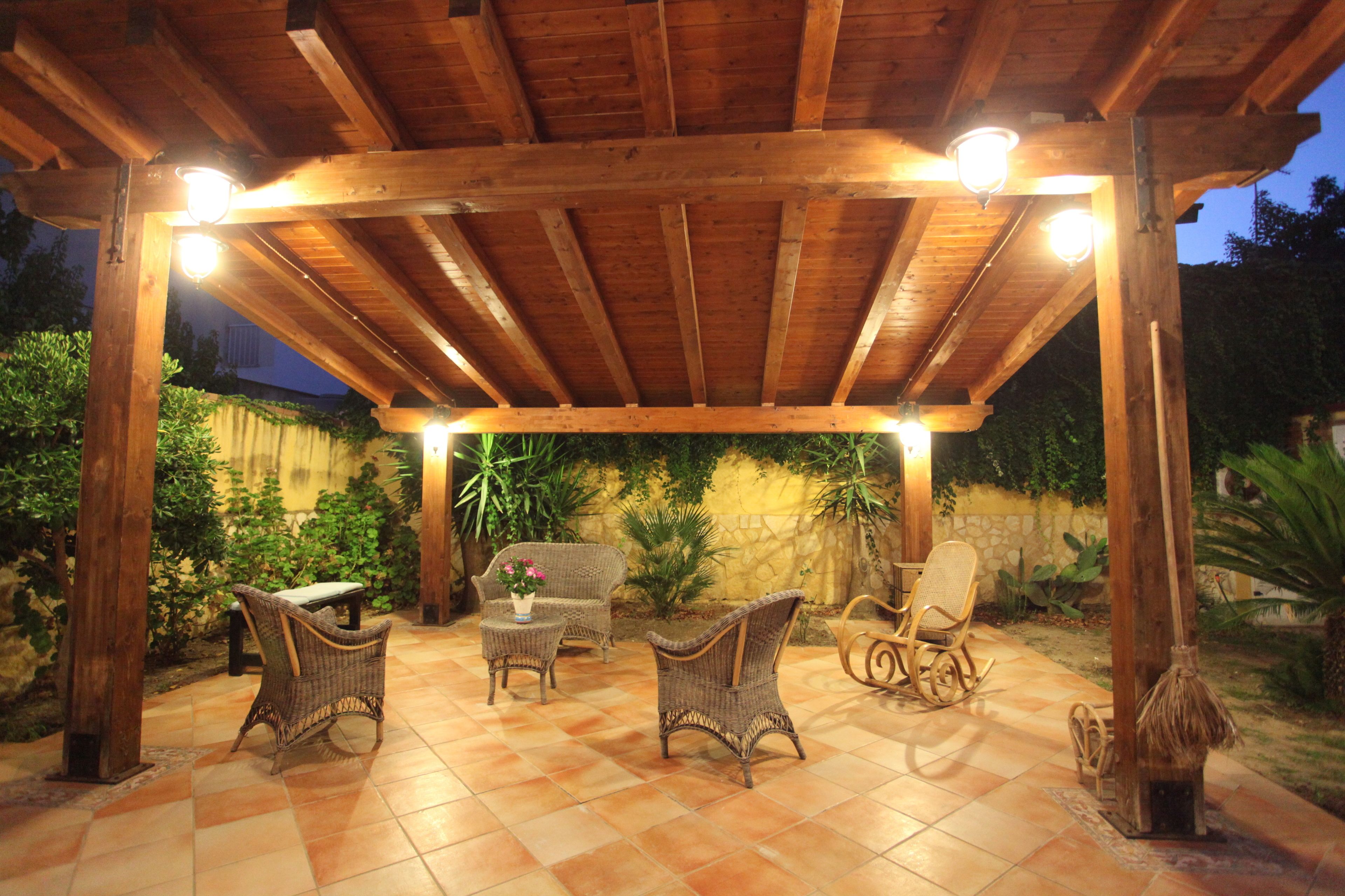 Un patio al aire libre con mobiliario de madera y suelo de baldosas.