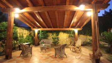 Un patio al aire libre con mobiliario de madera y suelo de baldosas.