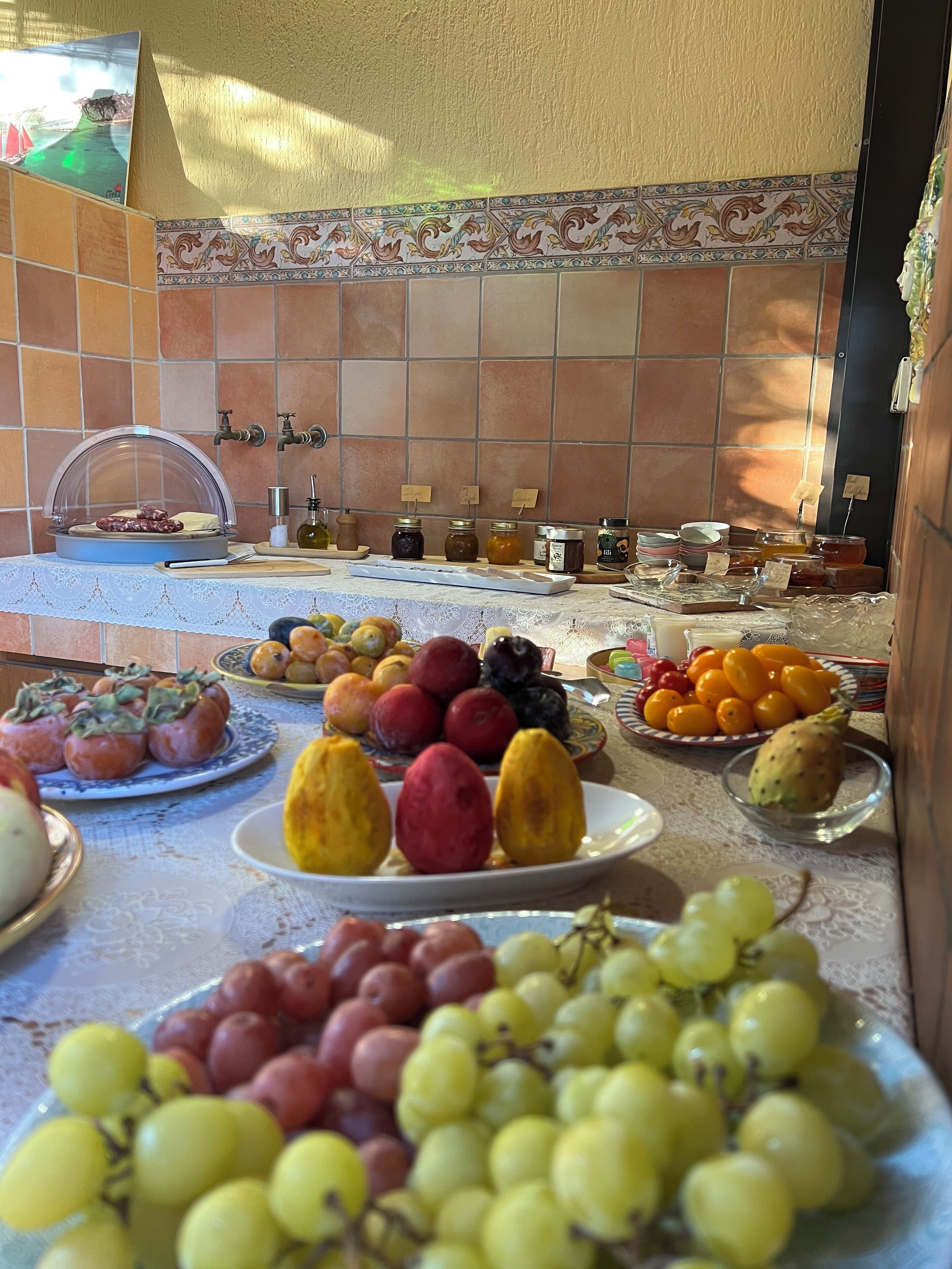 A kitchen with a tiled backsplash, a sink, and various food items on the counter.