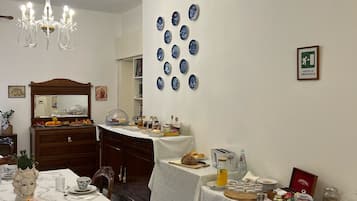 Un espace repas agrémenté d’un lustre, un mur avec un panneau indiquant la sortie de secours et un buffet.