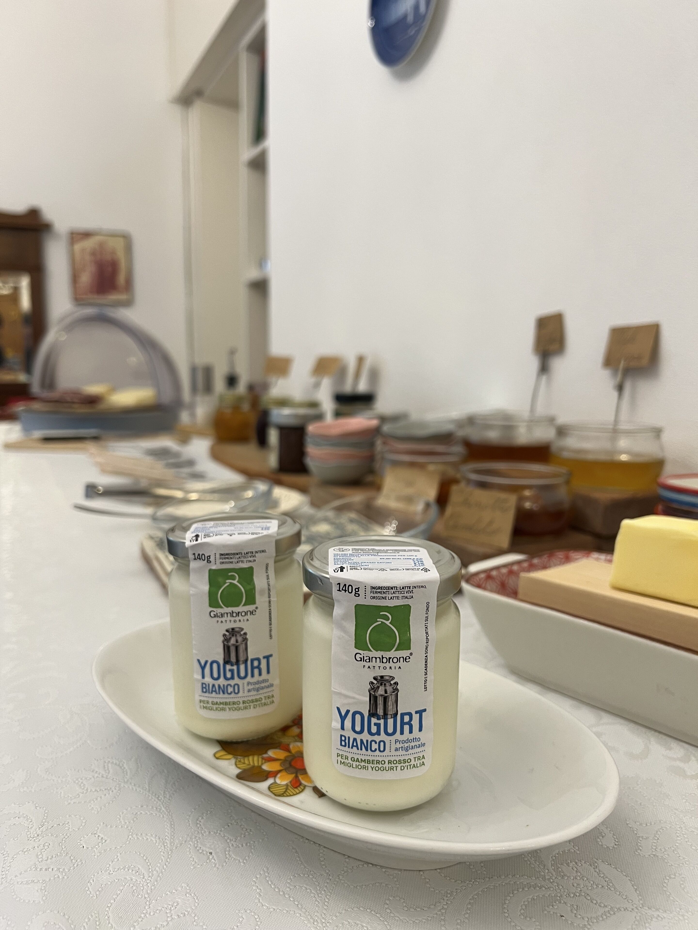 Two containers of Giambrone yogurt on a white plate.