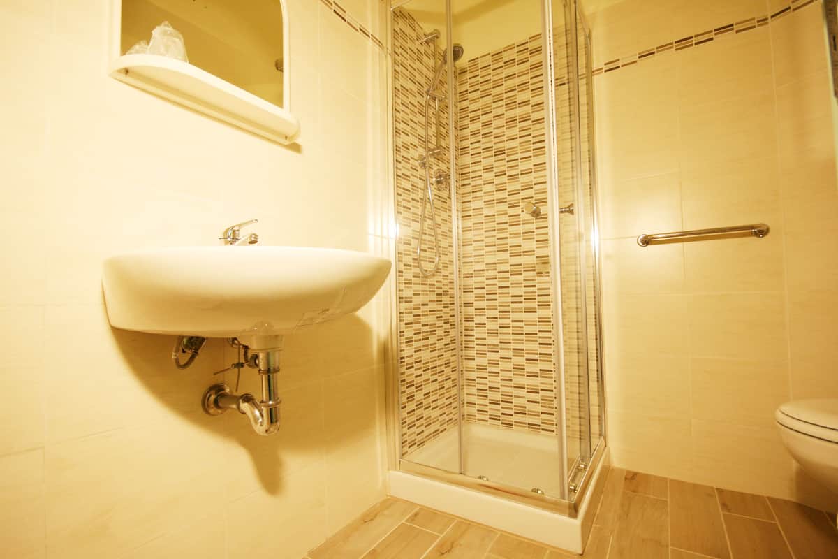 A bathroom with a sink, shower, and toilet.