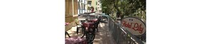 A hotel sign with outdoor seating and a view of the street. - Hotel Lily (Rimini)