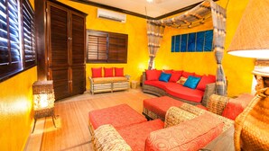 Una habitación con un conjunto de sofás, una lámpara de pie y un ventanal con persianas.