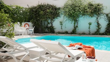 Piscine extérieure, parasols de plage, chaises longues