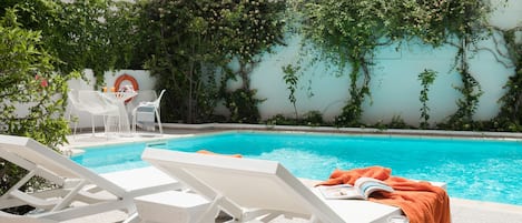 Piscine extérieure, parasols de plage, chaises longues