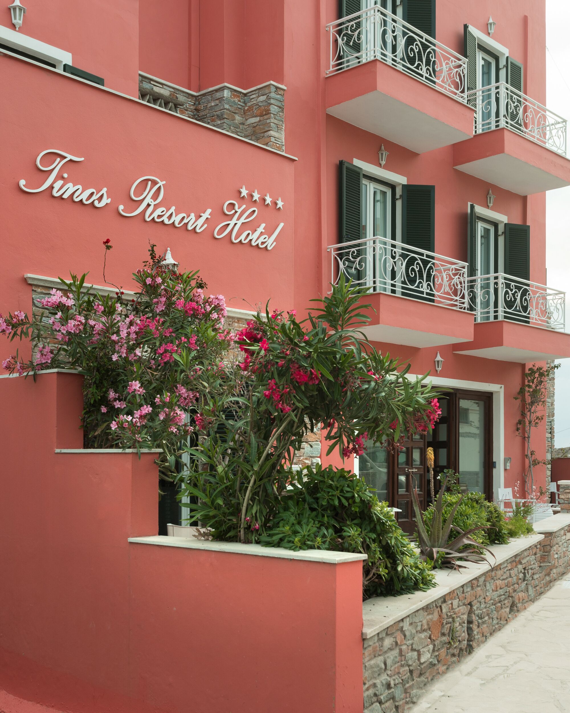 Un edificio rosa con balcones y un letrero que dice "Times Resort Hotel".