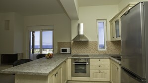 Una cocina moderna con una isla grande, electrodomésticos de acero inoxidable y vistas a través de las ventanas.