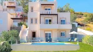 Un edificio moderno de varios pisos con piscina, zona de estar exterior y una escalera que conduce a los niveles superiores.