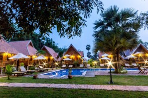 A resort with multiple bungalow-style buildings, a central swimming pool, and outdoor seating areas with umbrellas. - Angkor Heart Bungalow (Siem Reap)