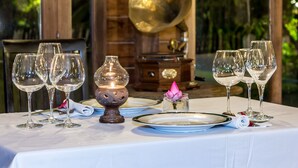 A table set with wine glasses, plates, and a decorative lamp. - Angkor Heart Bungalow (Siem Reap)