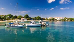 A marina with boats docked, calm water, and a coastal town in the background. - Coral Vista 3 2 bedroom option (Roatan)