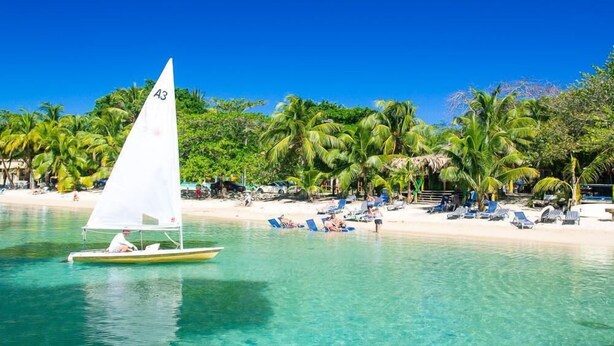A sailboat with a white sail labeled "A3" on a clear turquoise sea. - Coral Vista 3 2 bedroom option (Roatan)