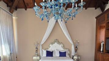 Un dormitorio con una cama grande, una araña y un florero con flores.