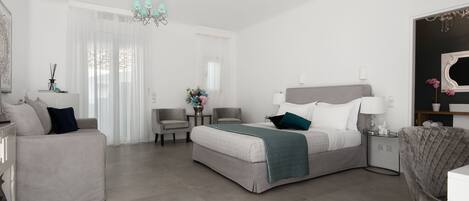 A modern bedroom with a bed, a sofa, a chair, and a small table.