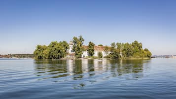Una propiedad tranquila junto al lago con un edificio destacado con una cúpula, rodeada de abundante vegetación.