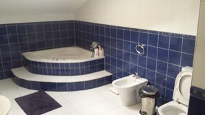 A bathroom with a bathtub, toilet, bidet, and sink. - Hostel do Ermal (Vieira do Minho)