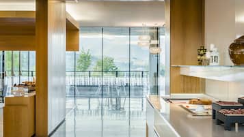 Una cocina moderna con separador de vidrio, detalles de madera y vistas al exterior.