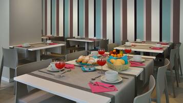 A modern dining area with striped walls, multiple tables, and chairs.