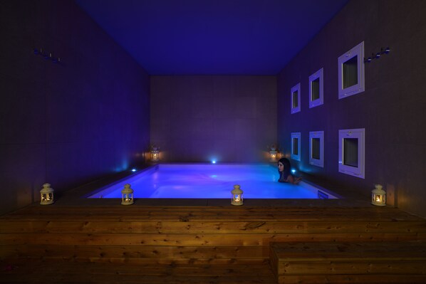 A wooden deck with a pool in the center, surrounded by walls with small windows. - Embassy Hotel & SPA (Cattolica)