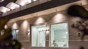 Een modern gebouw met een groot raam, een deur en een klein buitengebied met trappen.