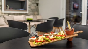 Een houten plank met etenswaren op een tafel in een moderne eetruimte.