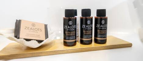 Three bottles of Zealots of Nature refreshing shampoo on a wooden tray.