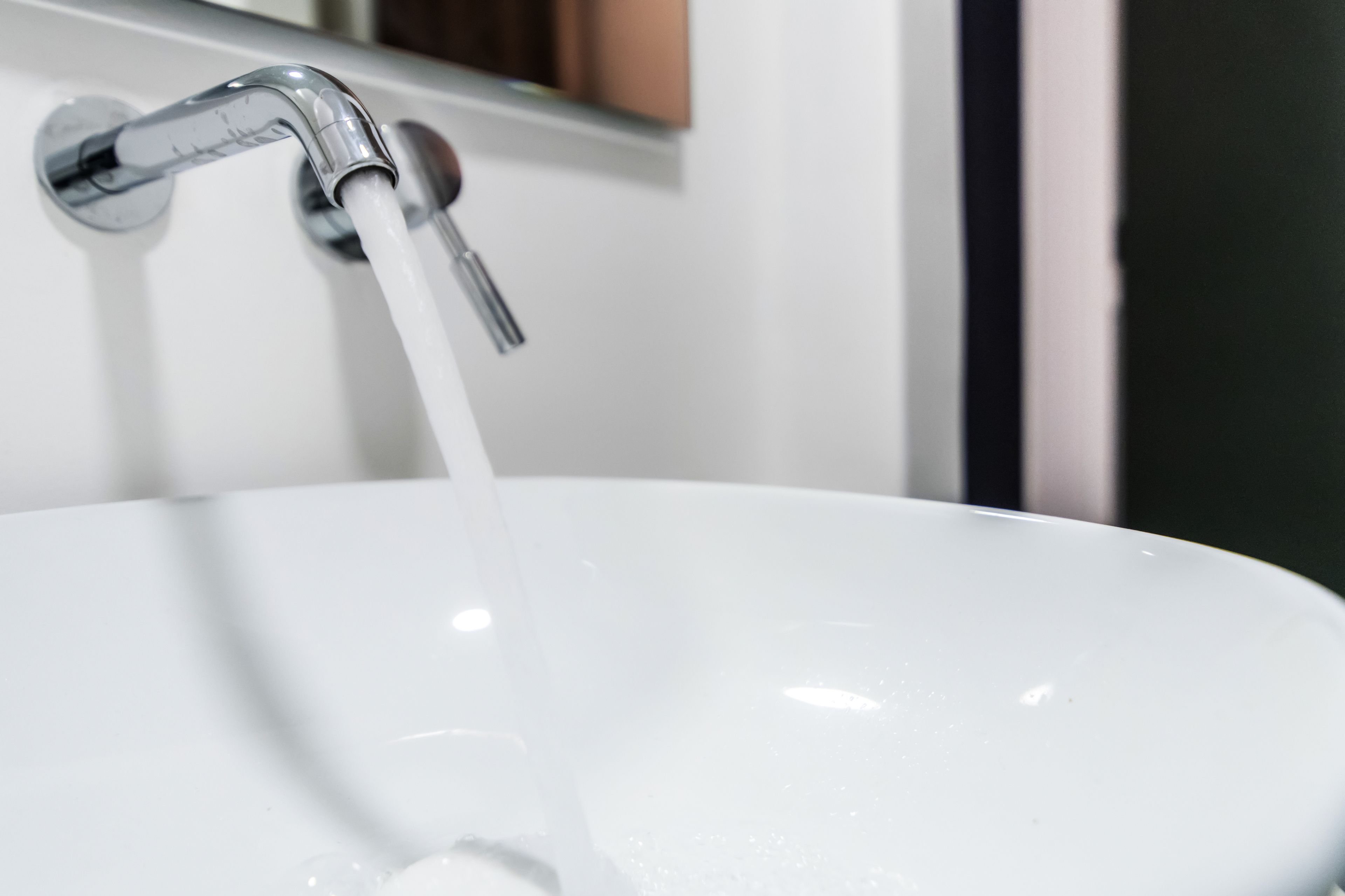 Un évier blanc avec de l’eau qui coule.