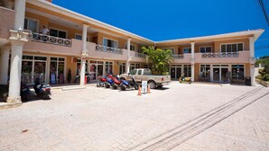 Un hotel con un cortile centrale, numerosi balconi e un camion parcheggiato.