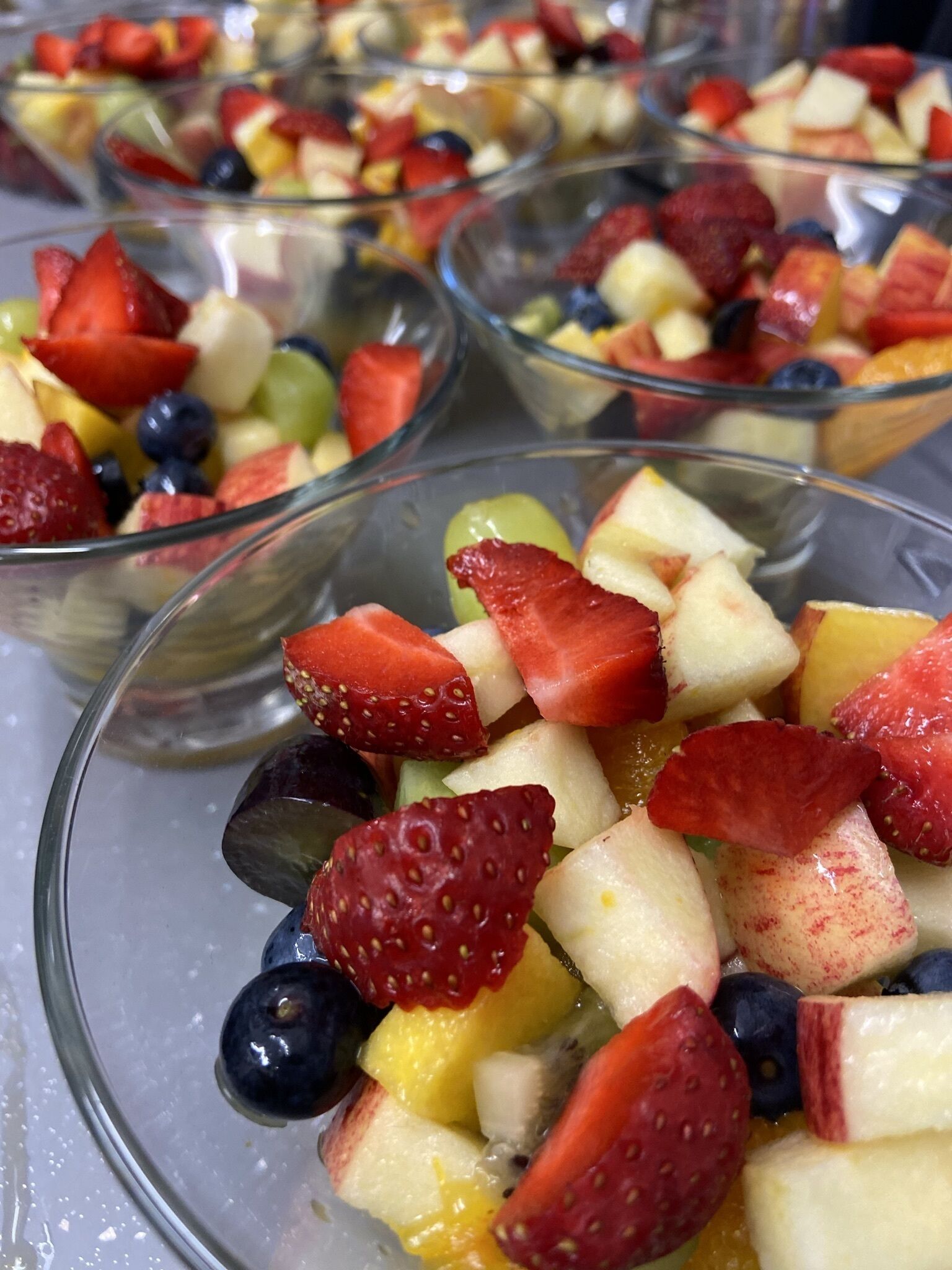 A close-up of fruit salad in clear glass bowls.