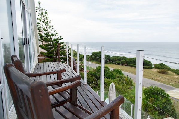 A wooden deck with two chairs overlooking a coastal view. - Whales Way Ocean Retreat (Wilderness)