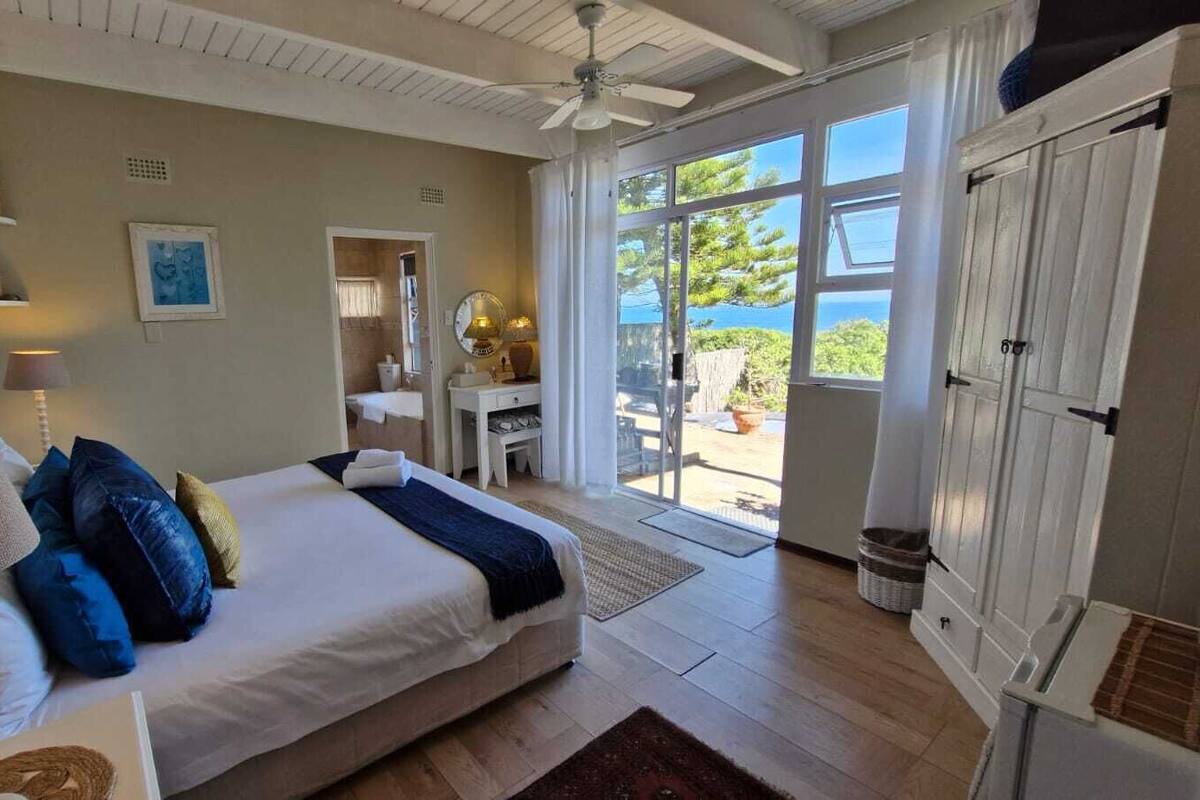 Une chambre à coucher avec un lit, une lampe de chevet et une vue sur l’extérieur grâce à une porte coulissante.
