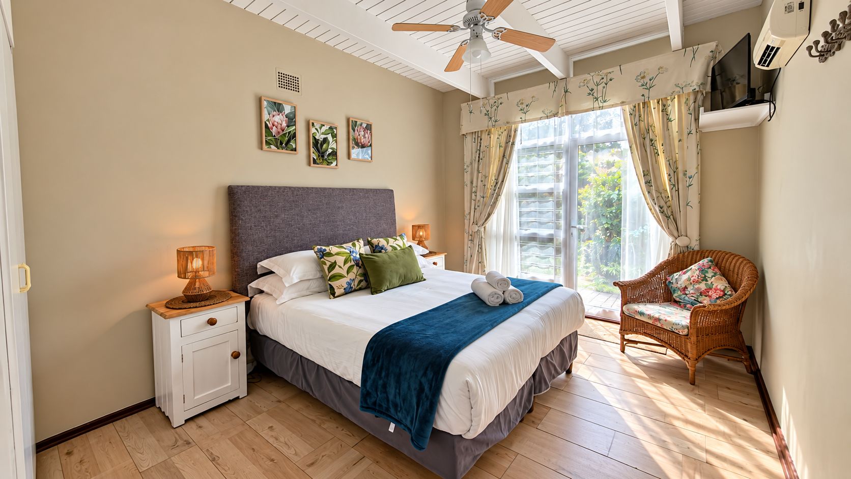 A bedroom with a bed, bedside tables, a chair, a ceiling fan, and a window with curtains.