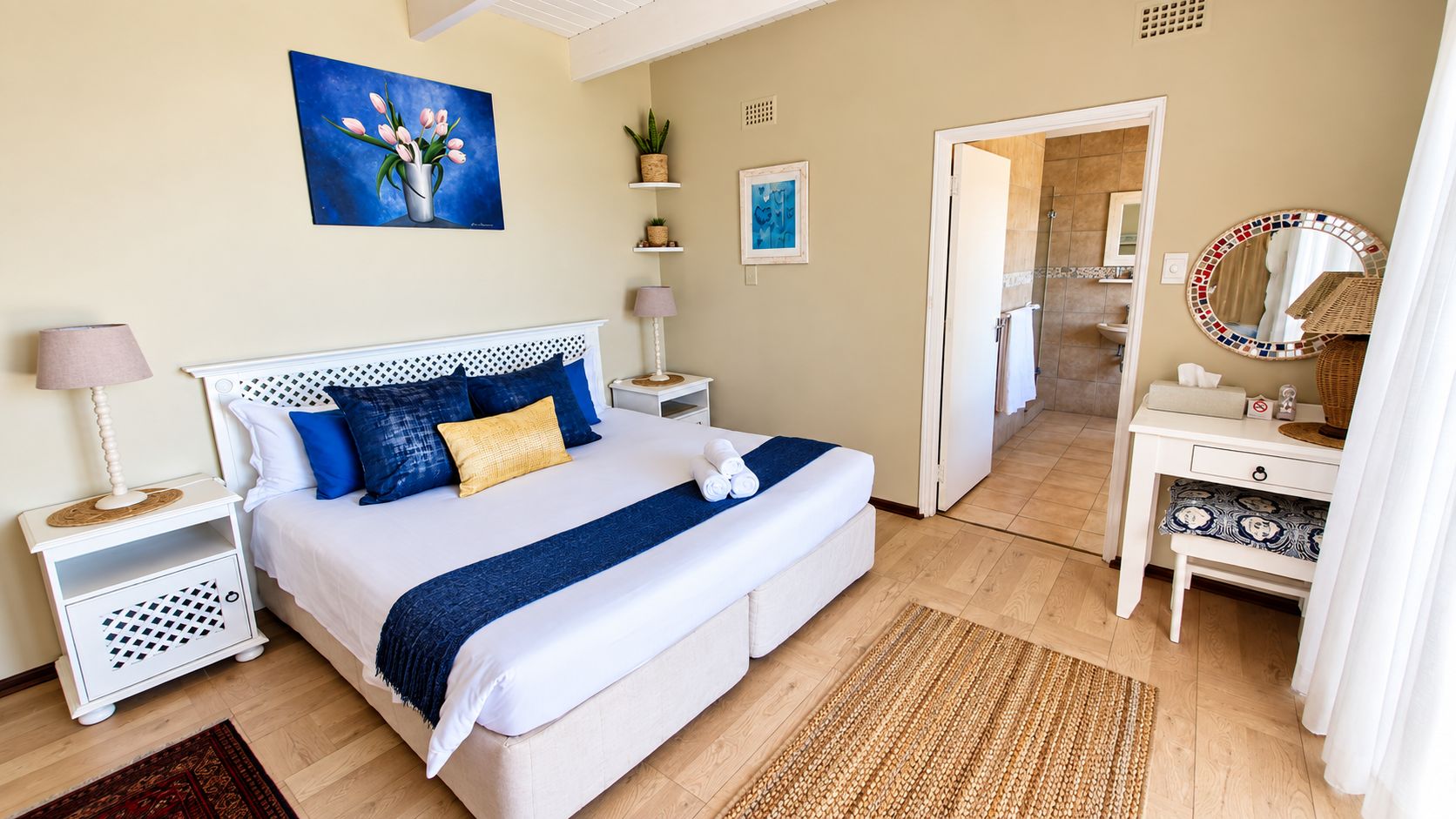 A bedroom with a bed, bedside tables, a dresser, and a mirror.