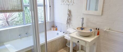 A bathroom with a bathtub, a sink, and a shower.