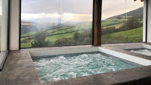 Un área de spa con un amplio ventanal que da a un paisaje pintoresco.