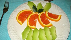 A plate with fruit slices arranged in a pattern. - The Guest House Pongola (Pongola)