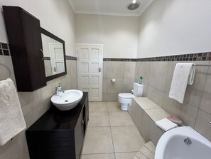 Une salle de bain avec un lavabo, des toilettes et une baignoire.