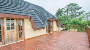 Een huis met een houten terras en een schuin dak.