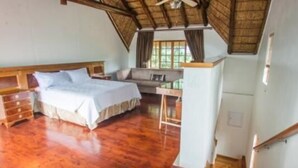 Een slaapkamer met een bed, een bureau en een stoel.