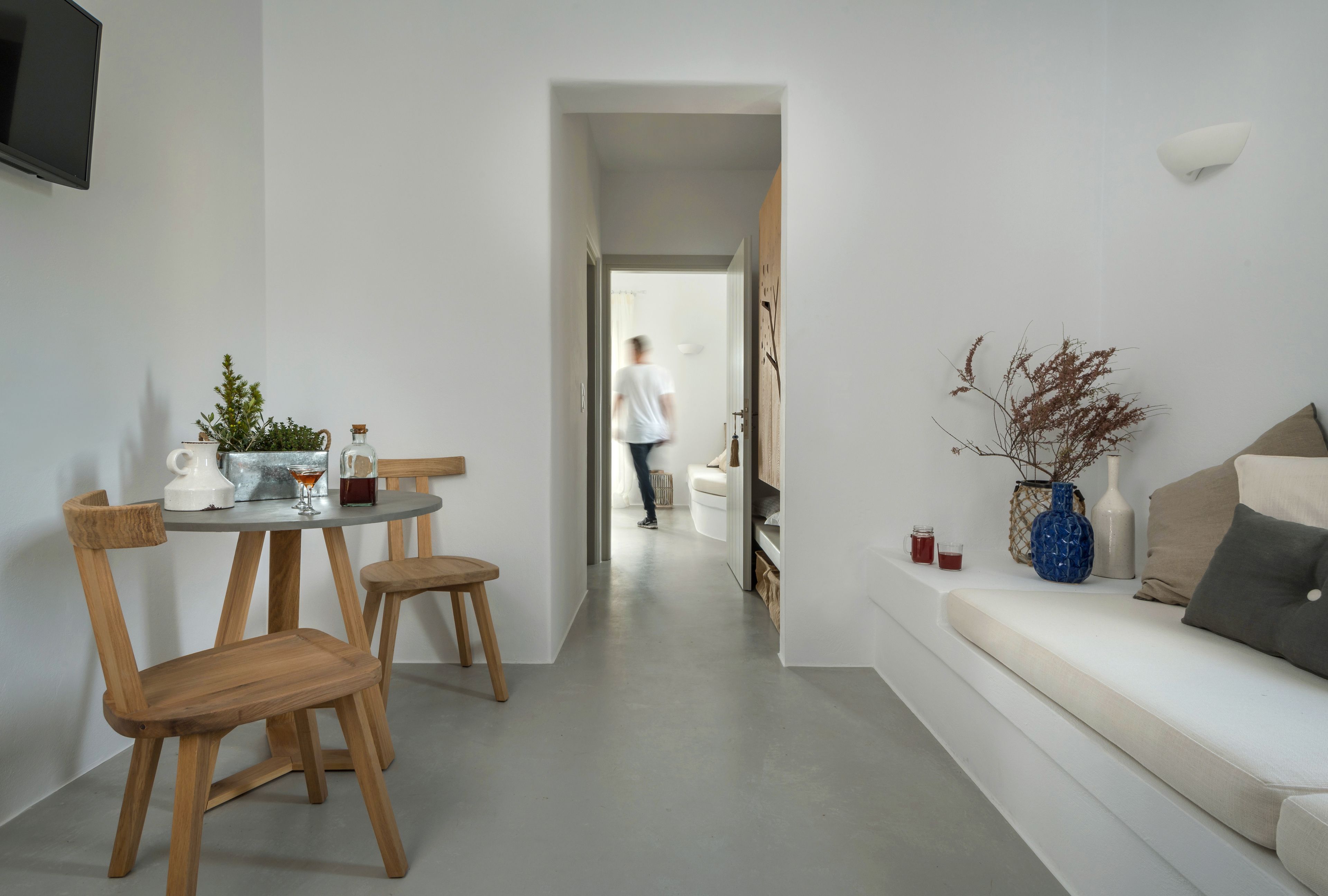 A modern living room with a sofa, a coffee table, and a dining area with chairs and a table.