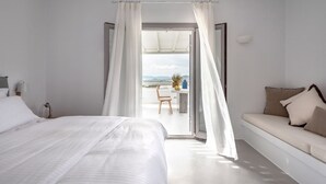 Un dormitorio con cama, sofá y vista al exterior.