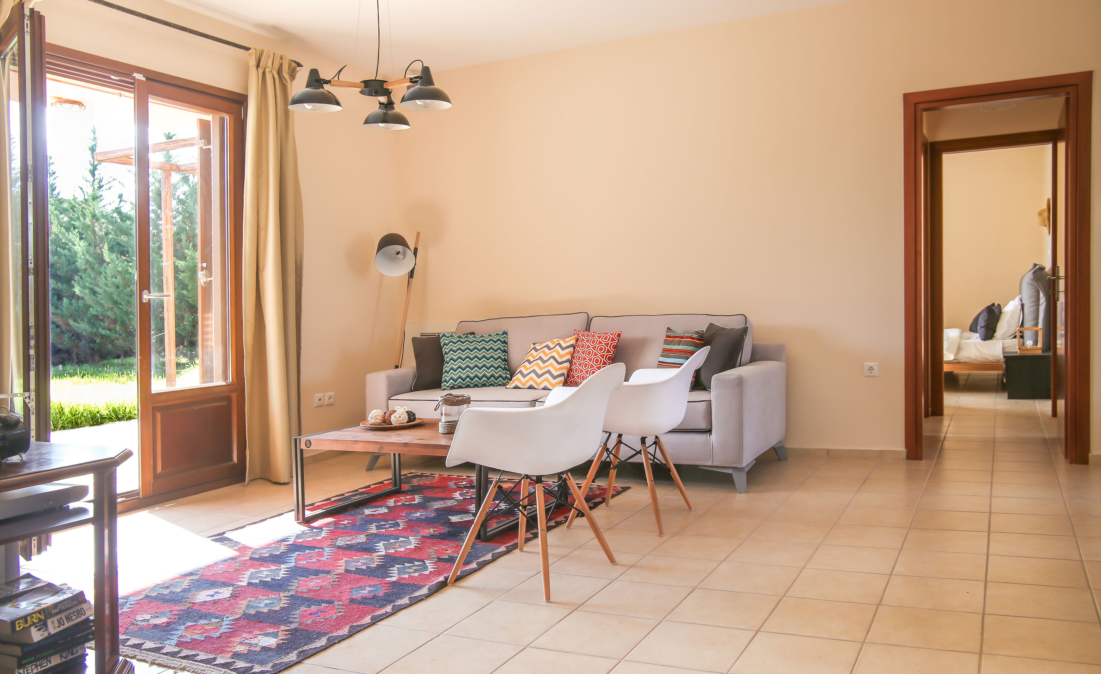 A living room with a sofa, chairs, a coffee table, and a patterned rug.