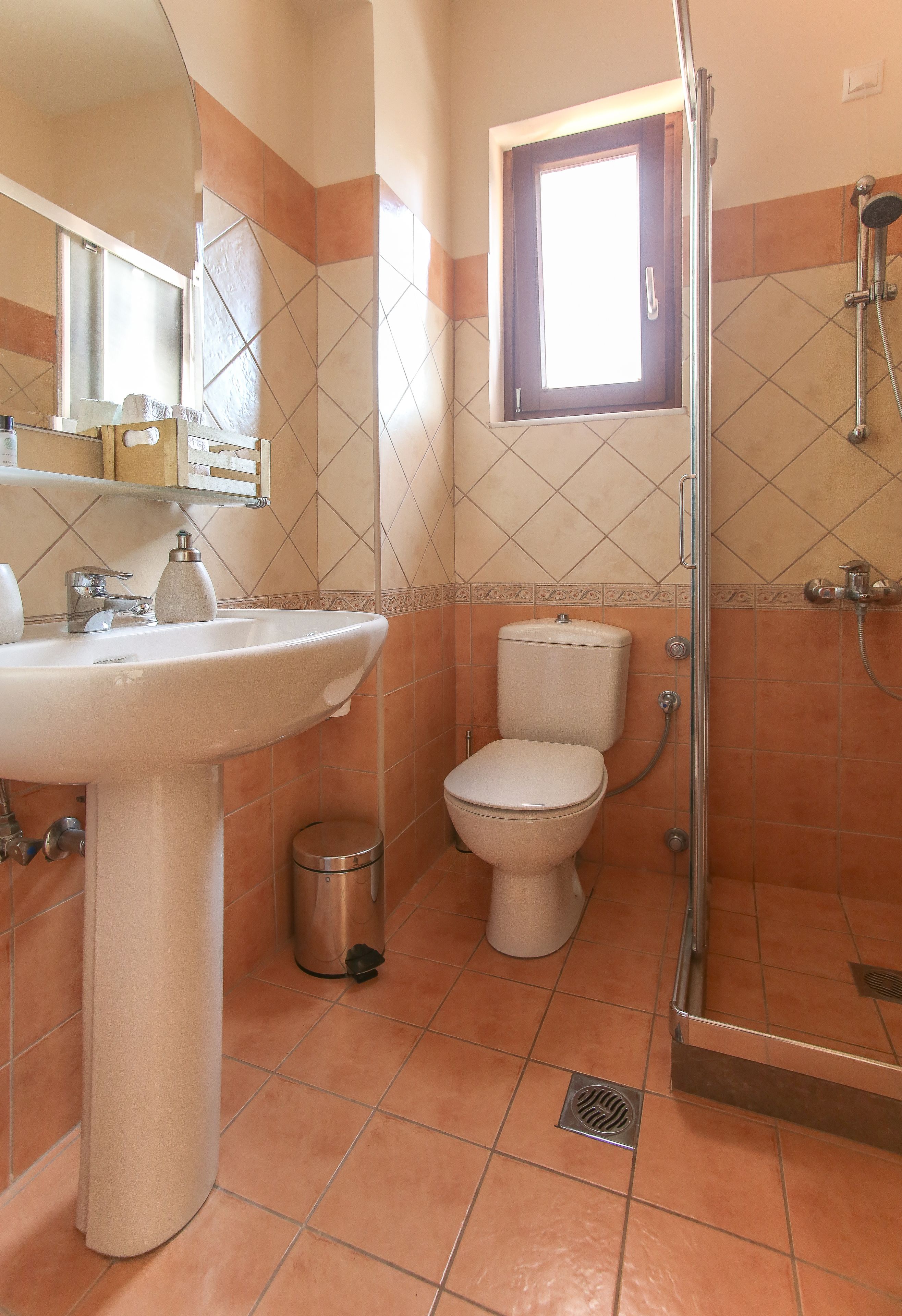 Un bagno con lavandino, wc e doccia.