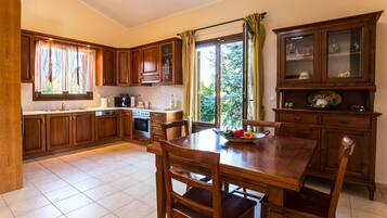 A kitchen with wooden cabinets, a dining table, and chairs.