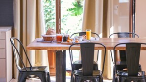 A breakfast table with a basket, croissants, juice, and a bowl of cereal. - Penelope Villas (Kefalonia)