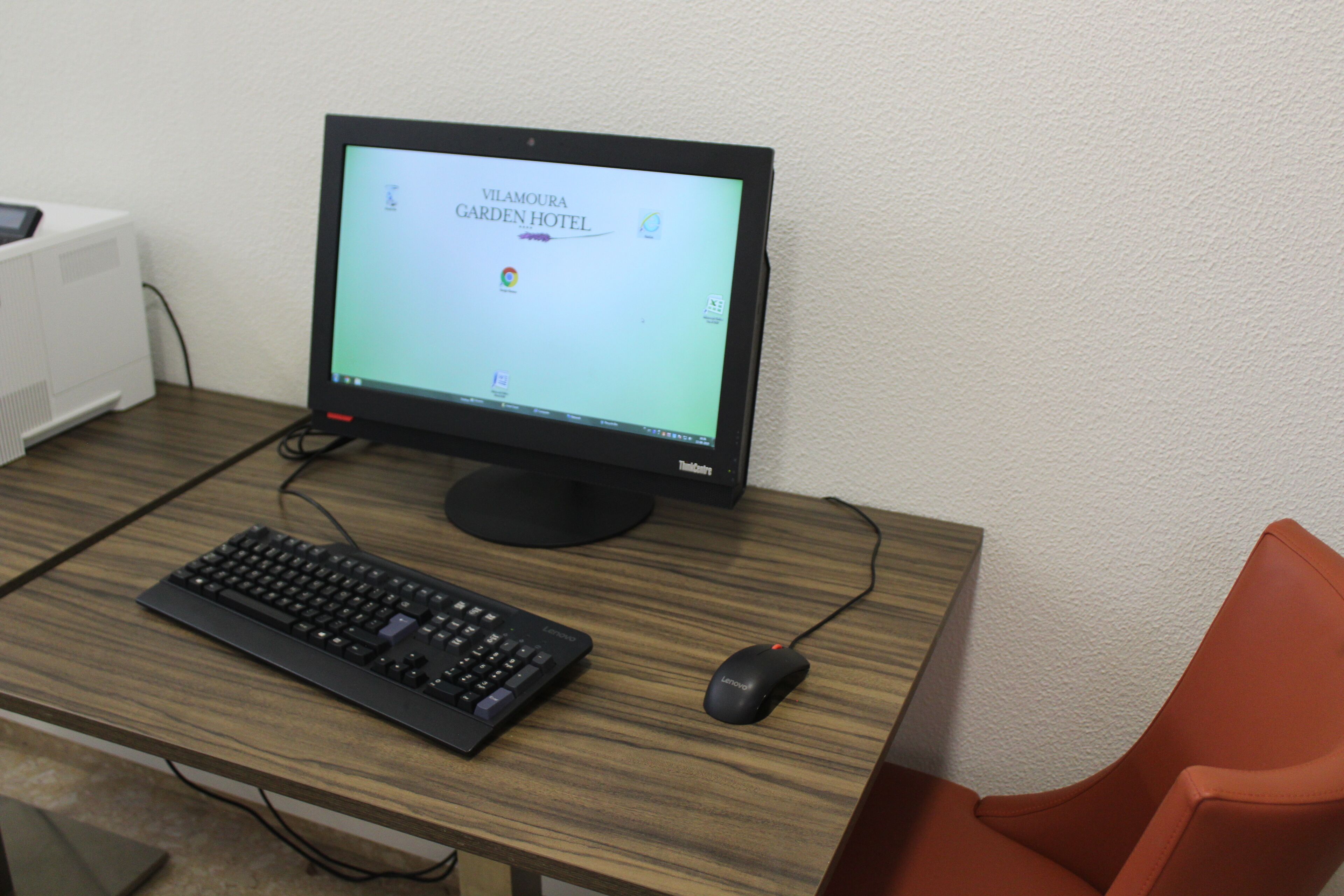 A computer setup with a monitor, keyboard, and mouse on a wooden desk.