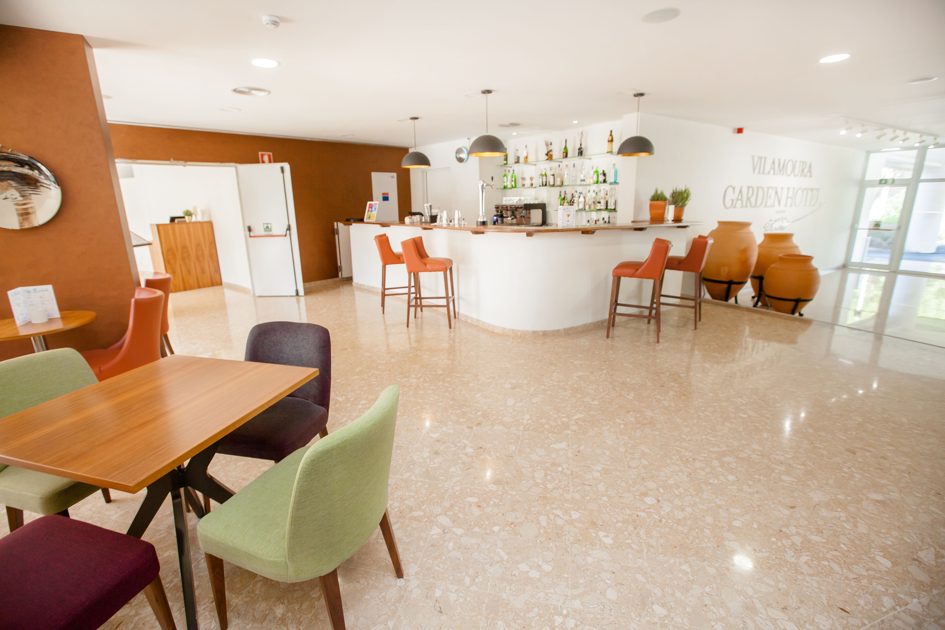 A modern hotel lobby with a bar area, seating arrangements, and a visible reception desk.