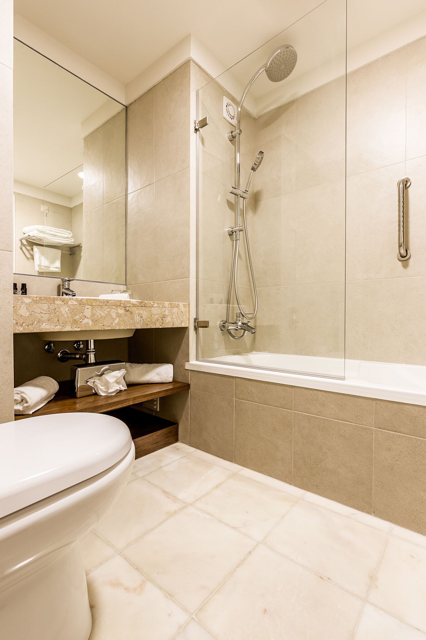 Un baño moderno con ducha, inodoro y lavamanos.